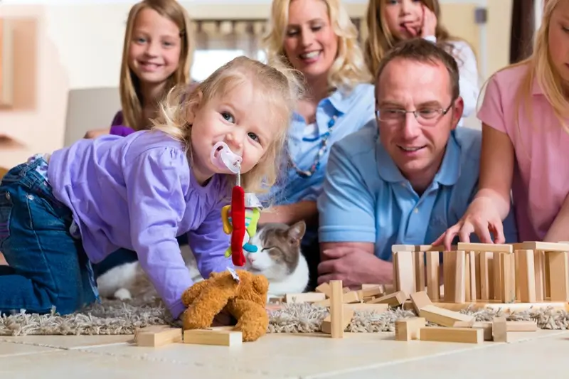 Family enjoying a traditional stacking game across generations